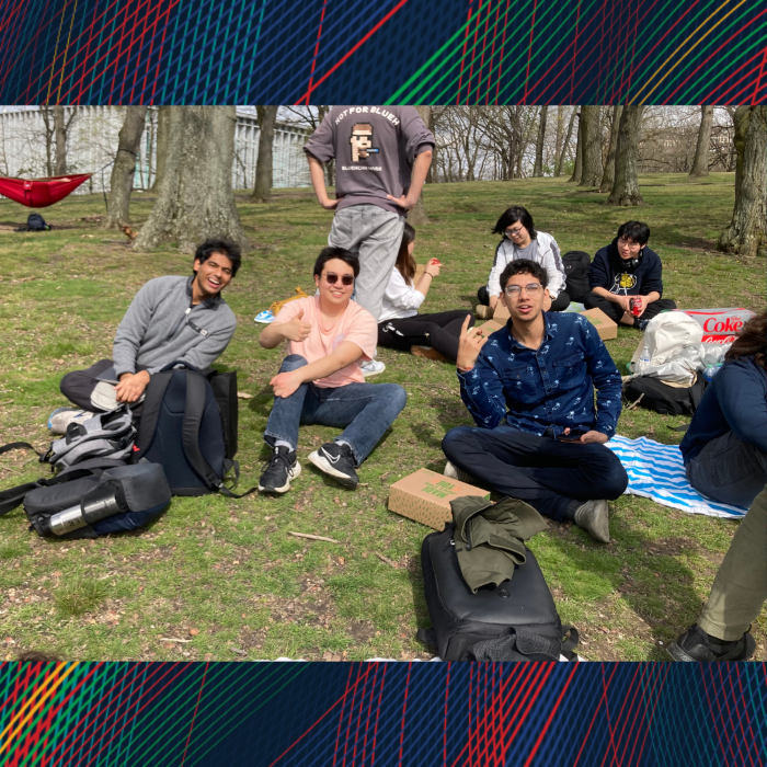 A group sitting the grass smile for the camera