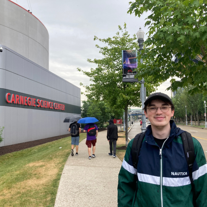 A man poses in front of the Carnegie Science Center