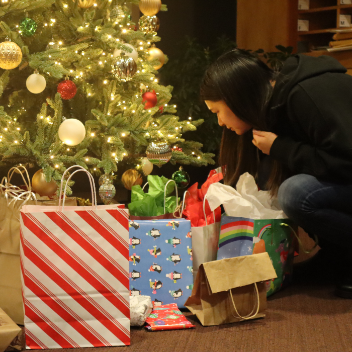 A woman choosing a gift from under the tree