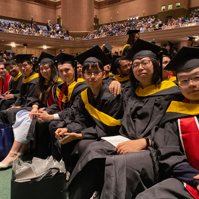 A group of students sitting in a line pose for the camera